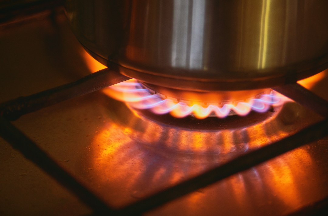 A pot on a gas stove burner with flames