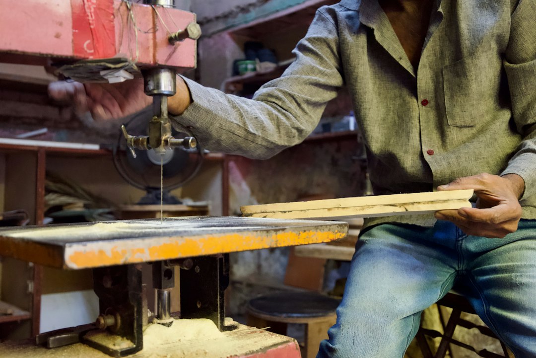 A carpenter cutting wood with a saw